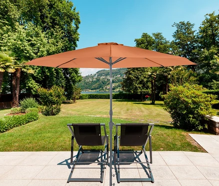 Zwei Liegestühle stehen auf einer Terrasse unter einem orangefarbenen Leco Sonnenschirm mit Ø 300 cm.
