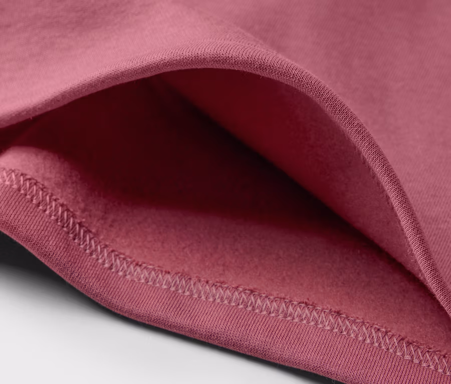 Detailansicht eines rosa Kinder-Sweatshirts mit angerauter Innenseite.