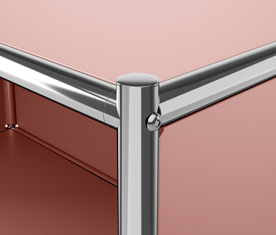 Detail einer Ecke eines modularen Möbelstücks mit einem Metallfuß und einer rotbraunen Platte.