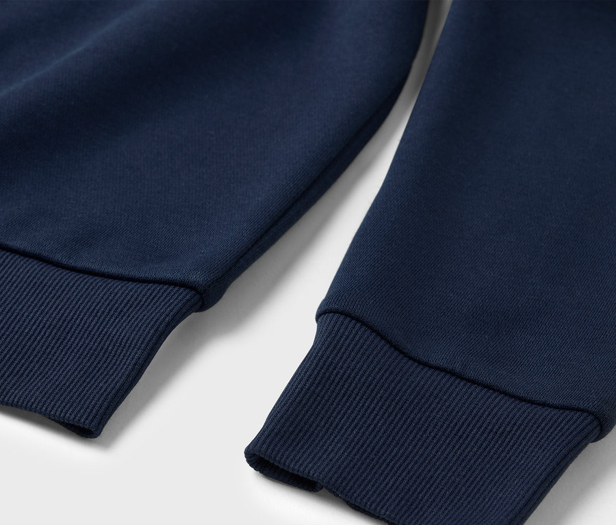 Detailaufnahme eines marineblauen Sweatshirts mit gerippten Bündchen.