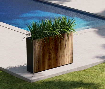 Grüne Pflanzen im braunen Herstera Garden Pflanzkasten »Divider« stehen am Pool.