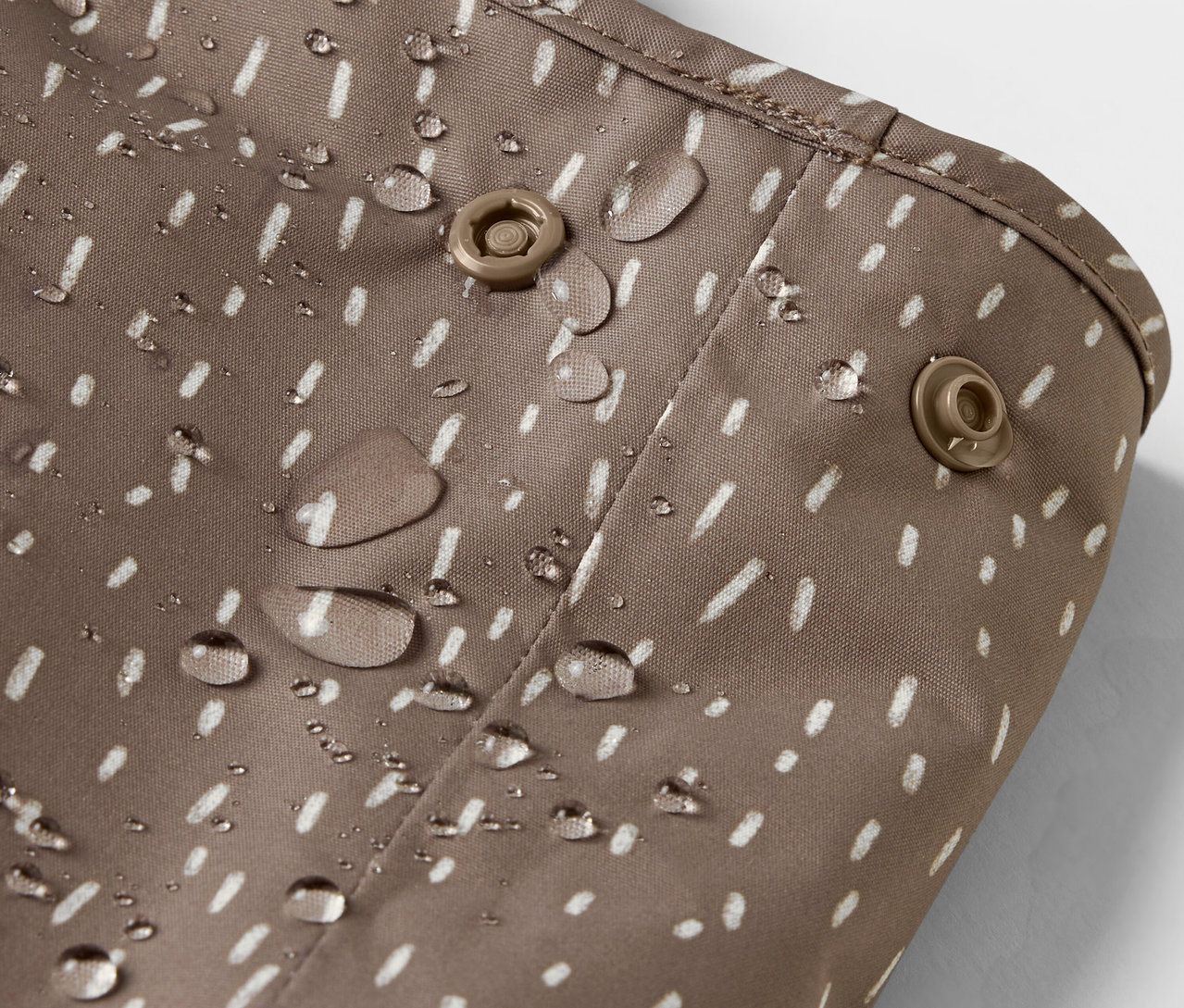 Detail einer Kinder-Thermo-Regenhose, Bär, mit Wassertropfen.