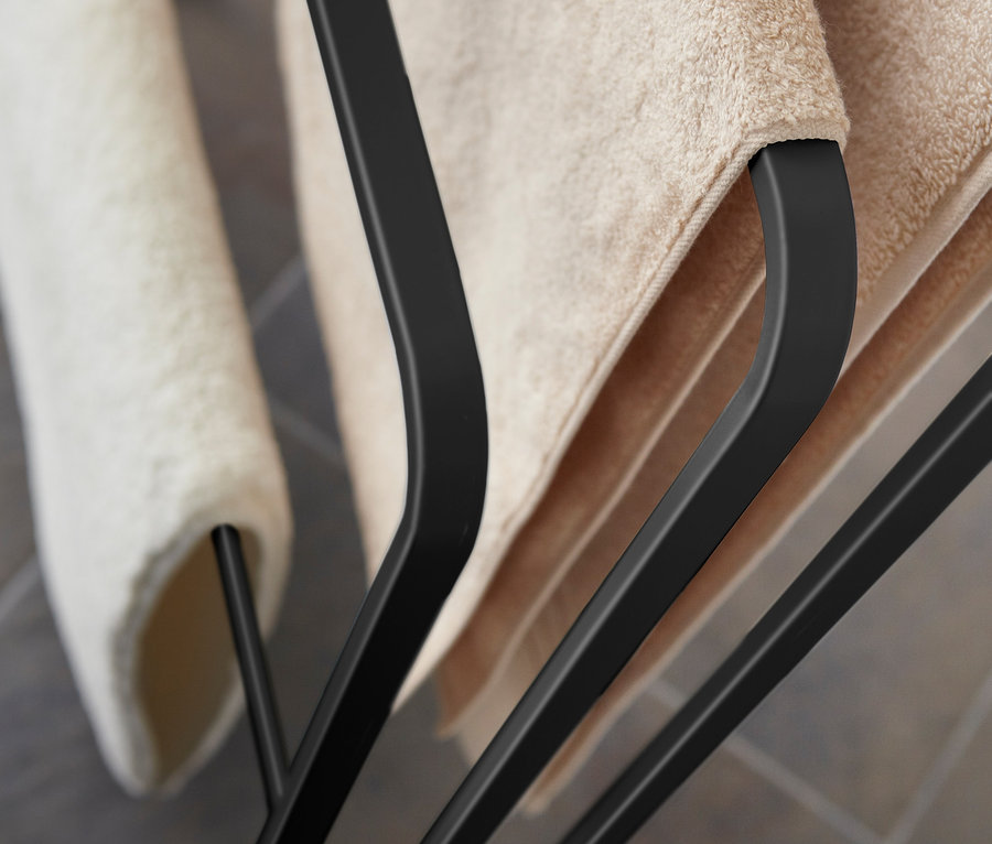 Detailansicht eines schwarzen YAMAZAKI Badehandtuch-Ständers »TOWER« mit beigen Handtüchern.