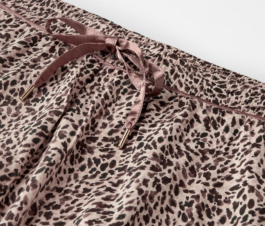 Detailaufnahme einer Leopardenhose mit braunem Kordelzug.