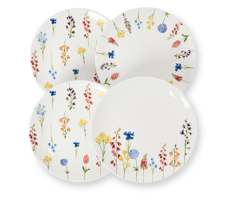 Vier Dessertteller mit Blumendekor liegen übereinander.