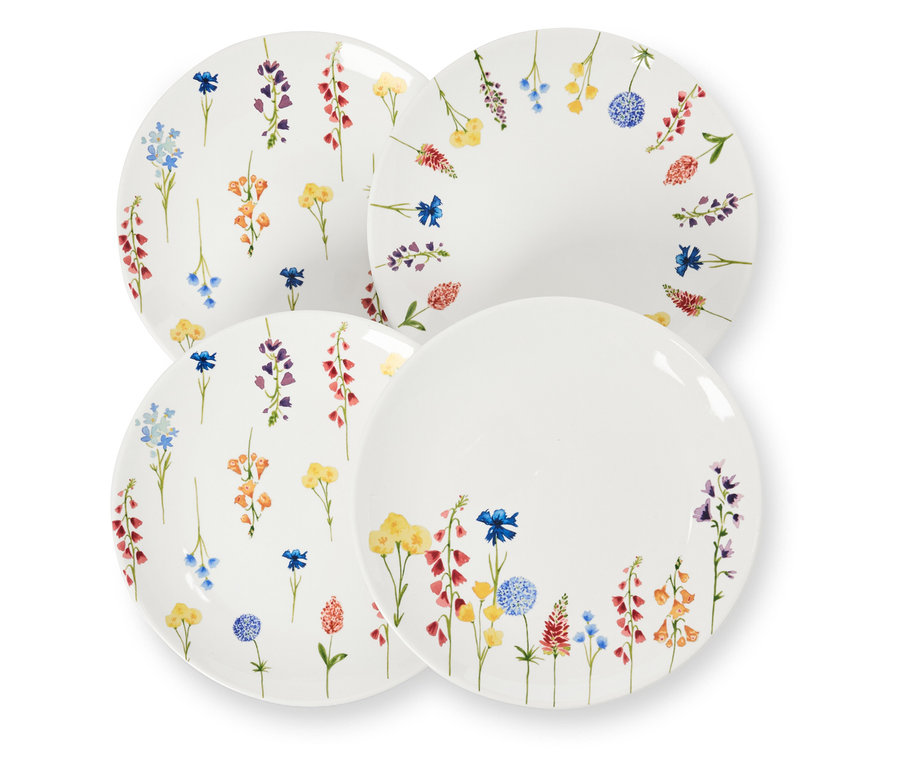 Vier Dessertteller mit Blumendekor liegen übereinander.