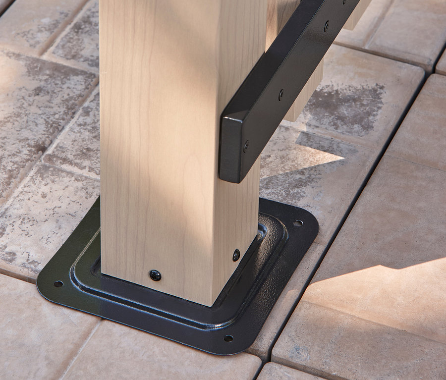 Detailaufnahme einer hellen Holzpfostenbasis mit schwarzer Metallhalterung auf Steinplatten.