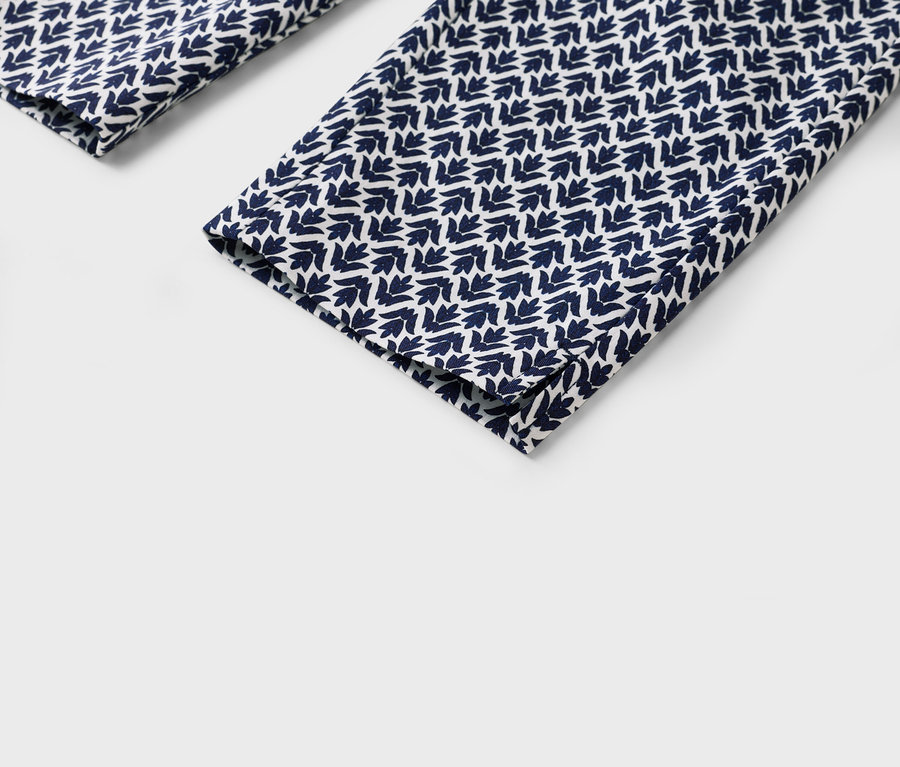 Nahaufnahme von Hosenbeinen mit blau-weißem Blattmuster.