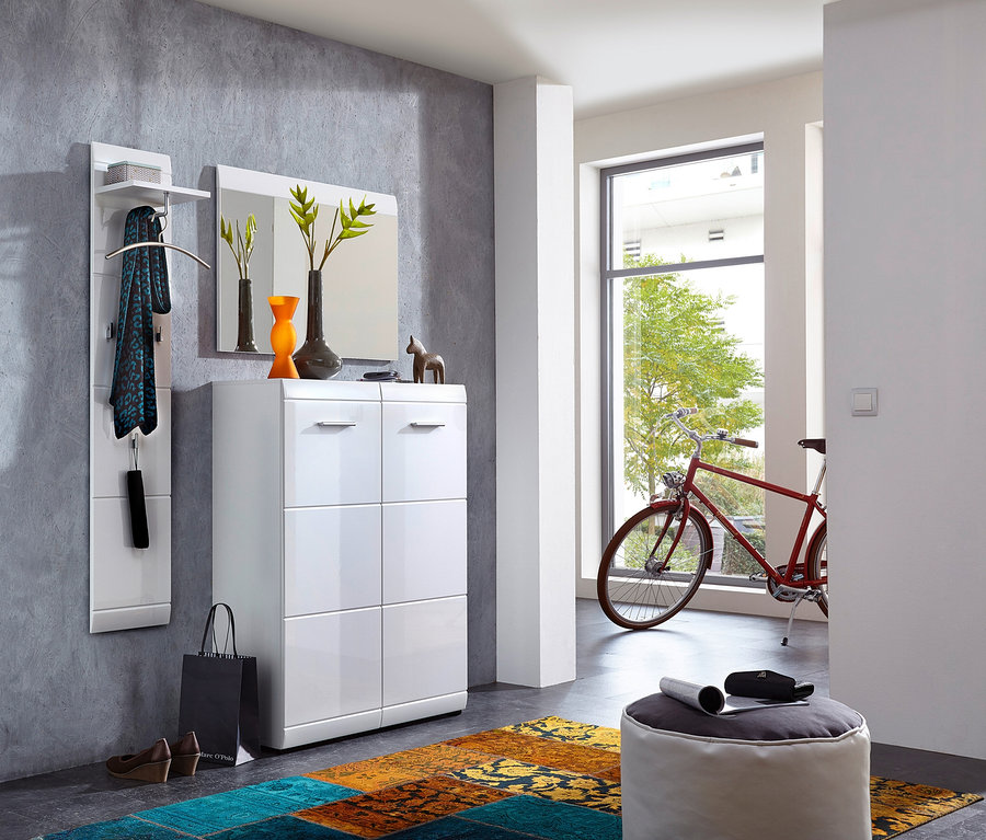 Eingangsbereich mit weißem Schuhschrank »ADANA« mit zwei Türen, Spiegel und Garderobe an grauer Wand. Ein rotes Fahrrad steht im Hintergrund.