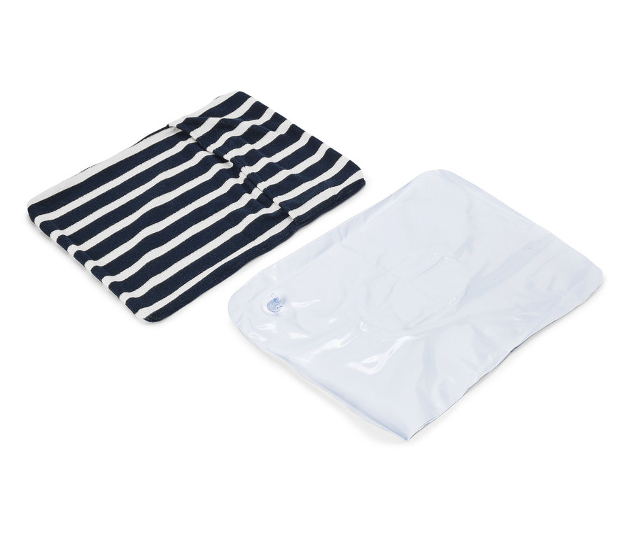 Gestreiftes marineblau-weißes Kleidungsstück und ein weißer Vakuumbeutel liegen auf weißem Grund.