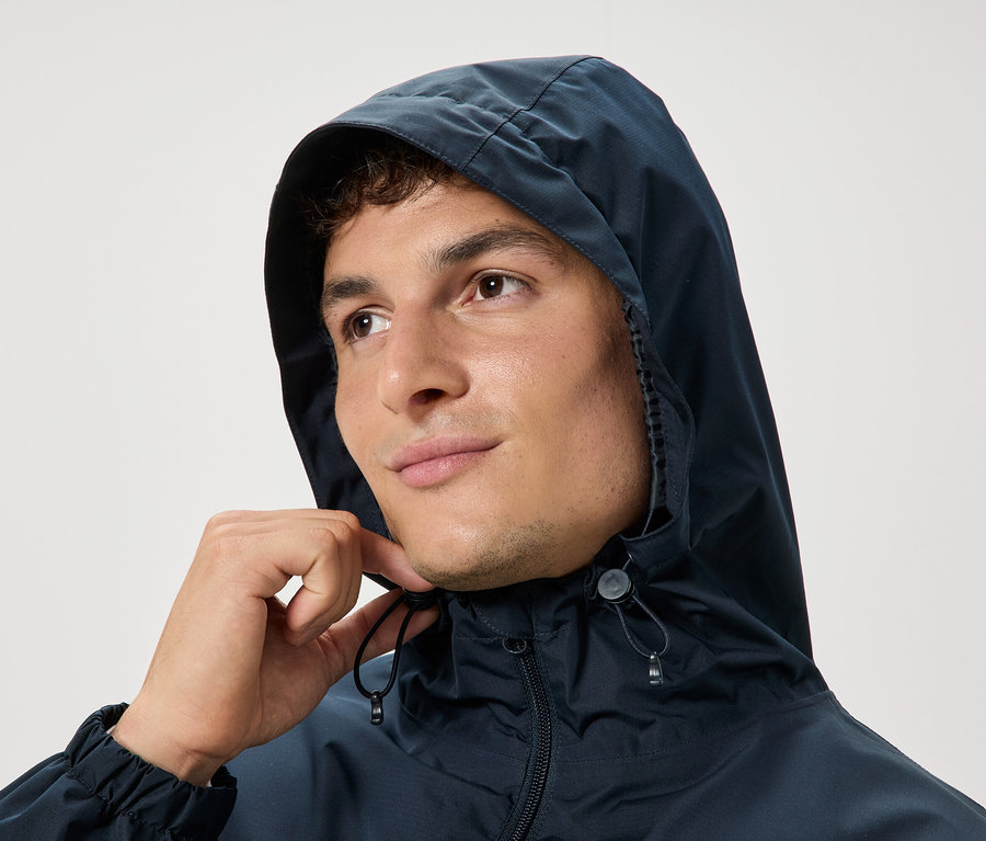 Mann mit Kapuze, der an den Kordeln zieht.