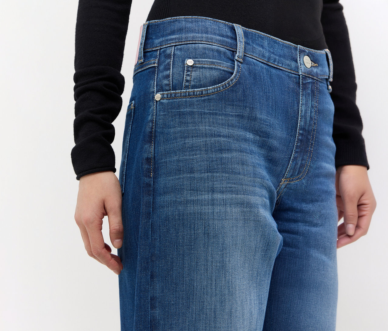 Person trägt blaue Angels Denim »Elly« Jeans und ein schwarzes Langarmshirt.