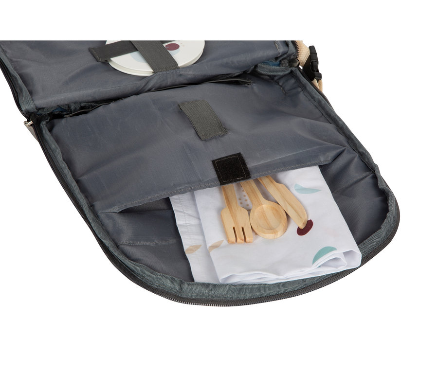 Offene Tasche mit Holzlöffel, Gabel und Messer auf einer bedruckten Serviette.