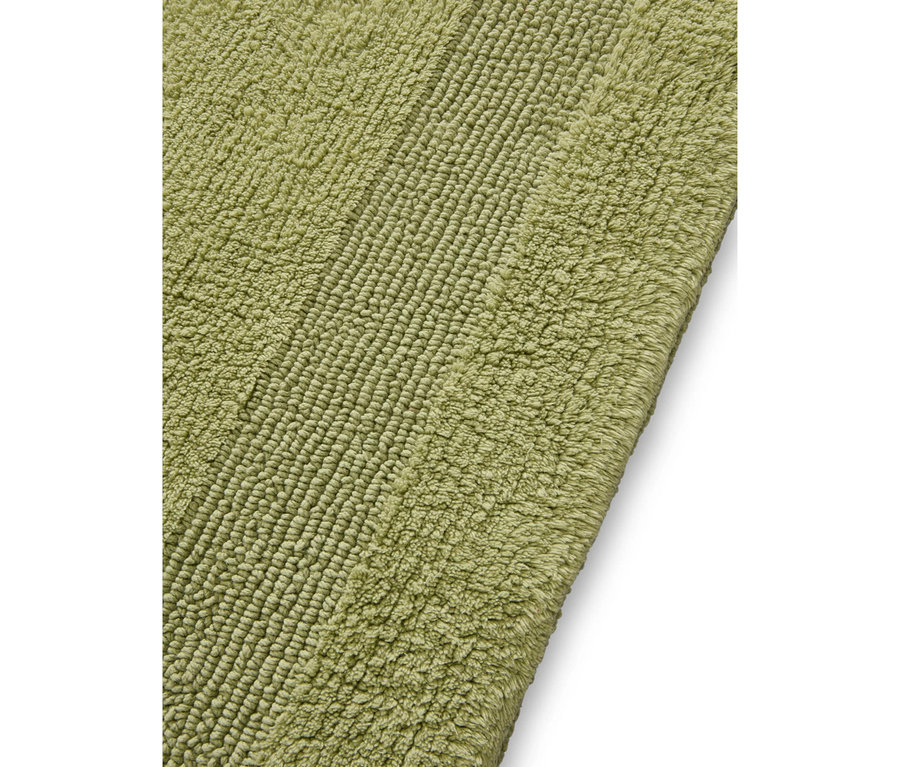 Grüner Badteppich mit zwei unterschiedlichen Texturen: eine gerippte und eine flauschige Oberfläche.