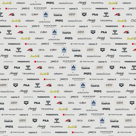 Ein sich wiederholendes Muster aus Logos verschiedener Marken, darunter Lurchi, Olsen, Seidensticker, Angels, Mama:licious, Sloggi, Triumph, Street One, Jako-O, Schiesser, Tom Tailor, Name It, Essenza, Passionata, Cecil, CMP, Irisette, Tempur, Schöner Wohnen Kollektion, Arena, Fila und Hummel.