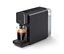 Eine schwarze »Qbo ONE« Kapselmaschine mit einem transparenten Wassertank rechts, die Kaffee in ein kleines Glas auf der Abtropfschale zubereitet.