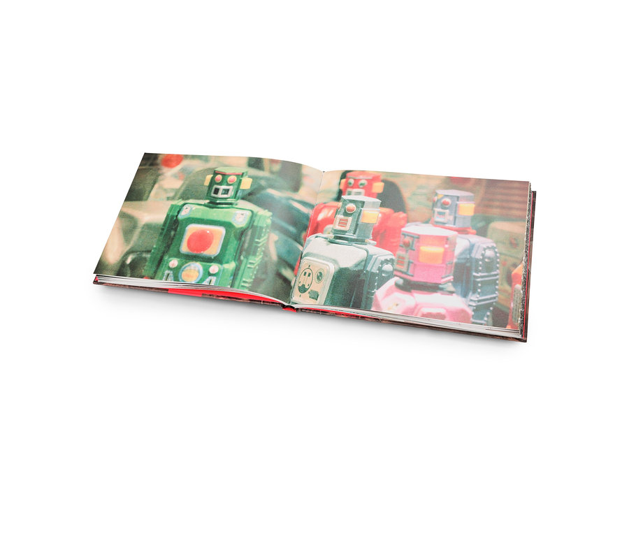 Offenes Buch mit Abbildungen von grünen, silbernen und roten Retro-Robotern.