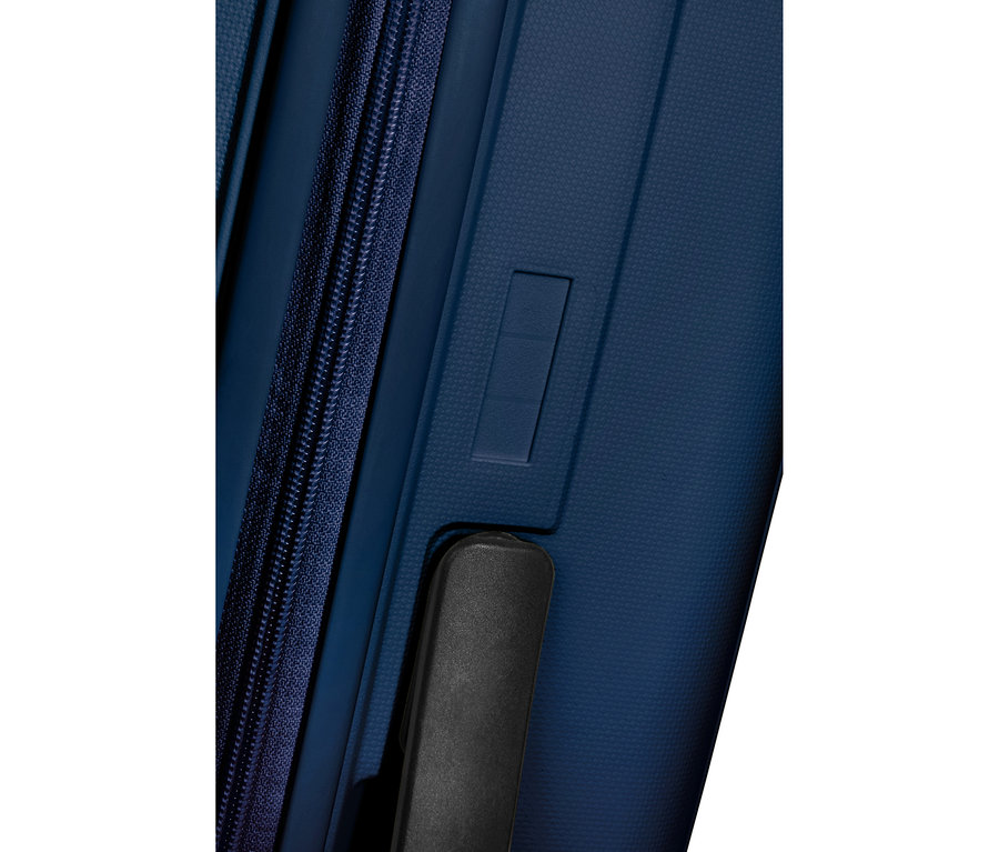 Nahaufnahme eines navyblauen American Tourister »Rejoy Spinner« Koffers, zeigt die strukturierte Oberfläche, einen vertikalen Reißverschluss links und einen schwarzen Griff unten rechts.