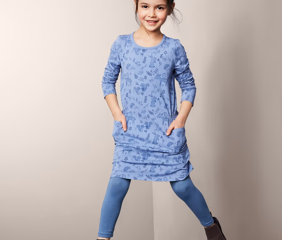 Mädchen in blauem Kleid mit Tiermuster und blauen 3 Leggings.