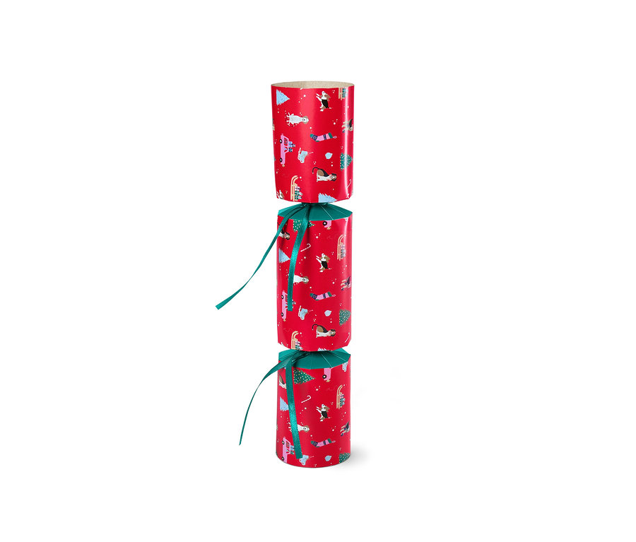 Ein DIY-Überraschungsbonbon in roter Verpackung mit Weihnachtsmotiven, mit einem grünen Band gebunden.