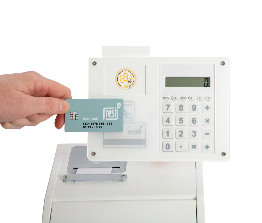Eine Hand hält eine Fresh Cash Karte an einer Small Foot Kasse "fresh".