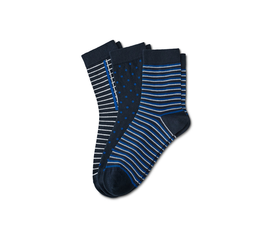 Drei Paar Socken mit verschiedenen Mustern. Ein Paar mit Streifen, ein Paar mit Punkten und ein Paar mit blauen und weißen Streifen.