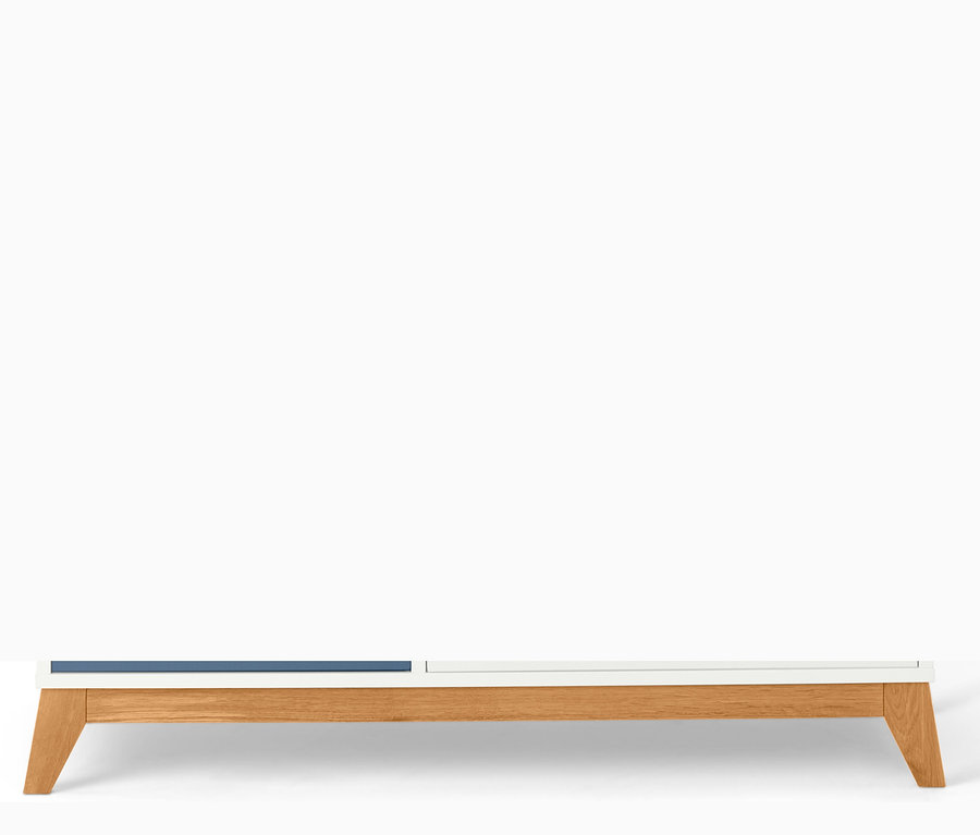 Detailaufnahme eines Kleiderschranks mit blauen und weißen Schubladen und Holzfüßen.