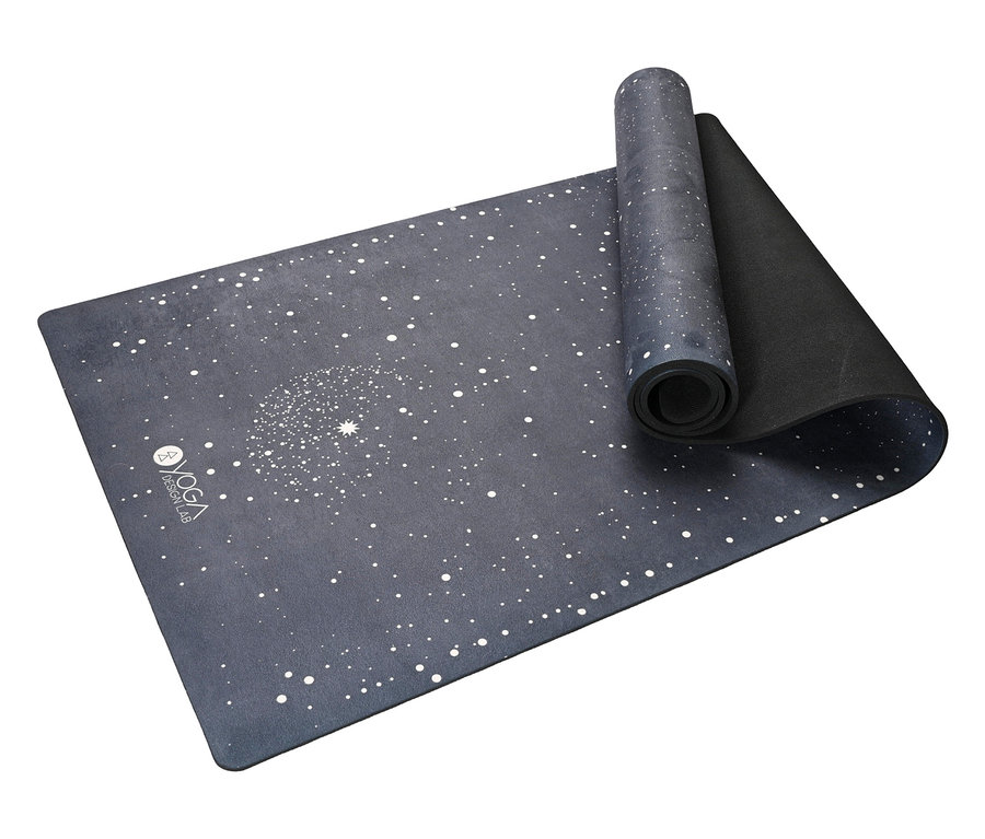 Eine teilweise zusammengerollte Yogamatte mit Sternenmuster auf dunkelblauem Hintergrund.