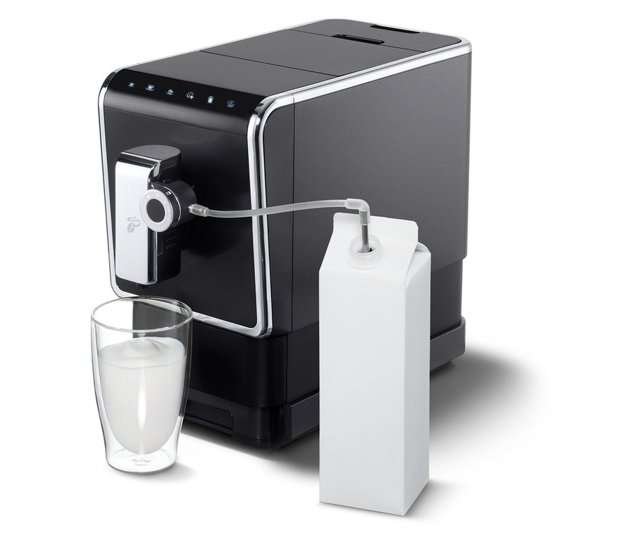 Anthrazitfarbener »Esperto Pro« Tchibo Kaffeevollautomat mit Milch im Glas und Karton.