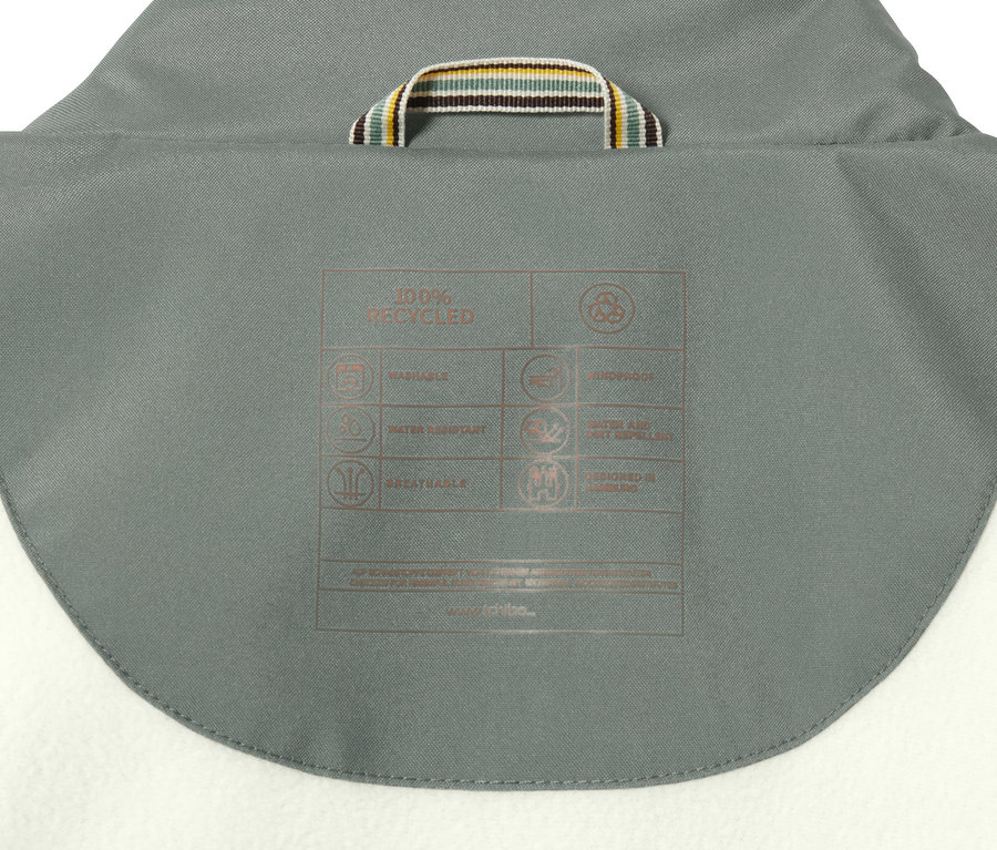 Detail der Kapuze des Regenparkas mit einem Etikett, das die Produkteigenschaften beschreibt.
