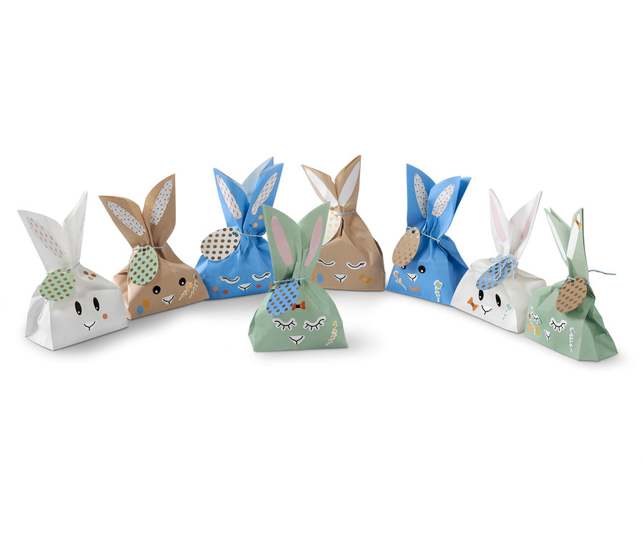 Sieben Osterhasen-Geschenktüten in Weiß, Braun, Blau und Grün.