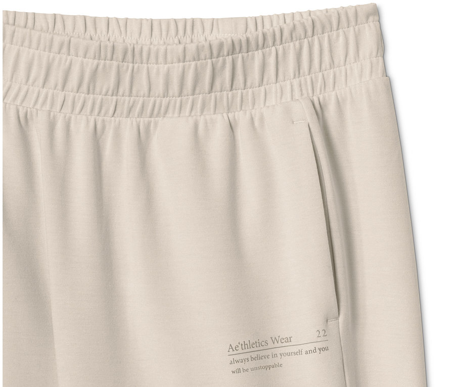 Detail einer beigen Extraweichen Sweathose mit Tasche und Aufschrift.