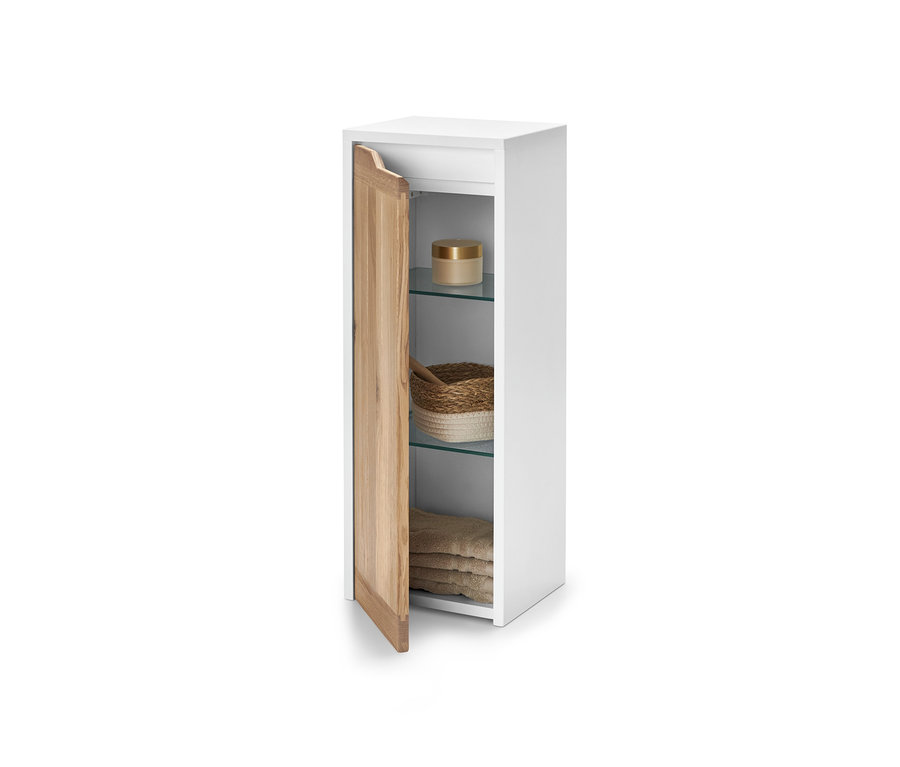 Weißer Beistellschrank mit offener Holztür. Innen befinden sich Regale mit Kosmetika, einem Korb und Handtüchern.