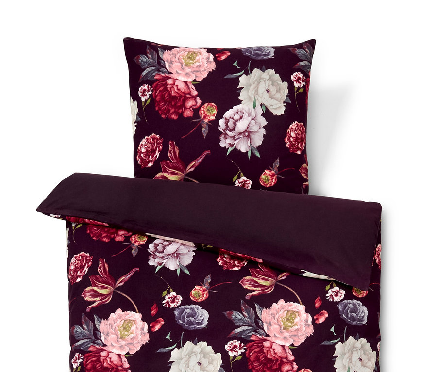 Frontale Aufnahme eines Bettwäsche-Sets mit Blumenmuster und einem Bettbezug.