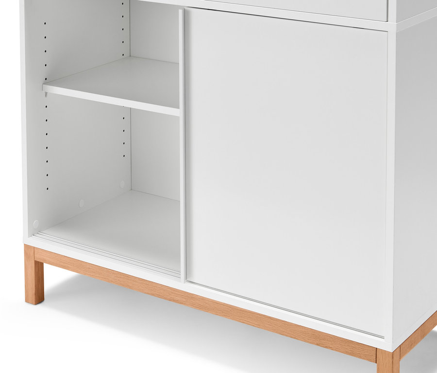 Detailaufnahme eines weißen Officeschranks zum Aufklappen mit Holzfüßen.