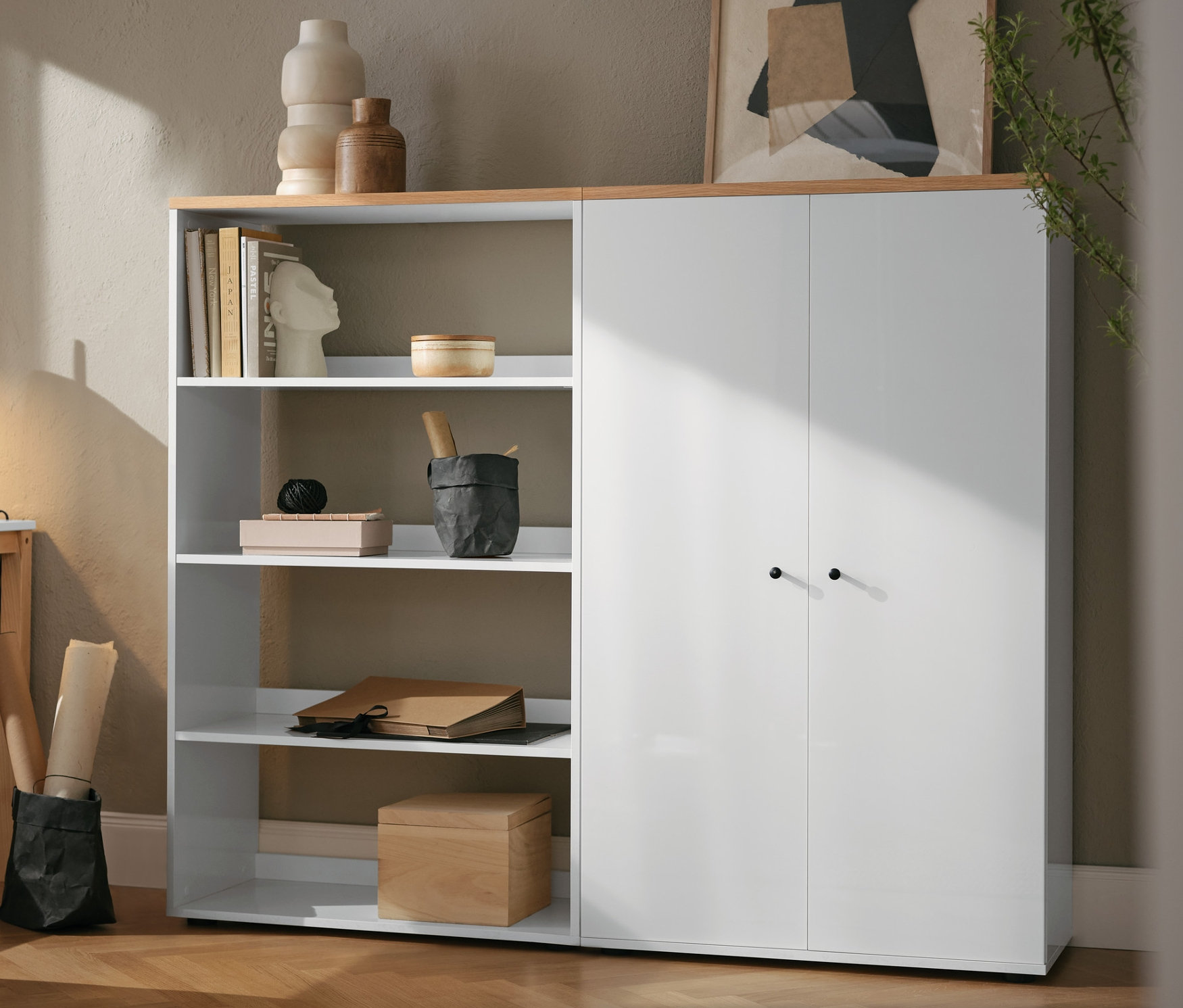 Eine schwarze Metalltischleuchte steht auf einem Tisch neben einem weißen Regal.