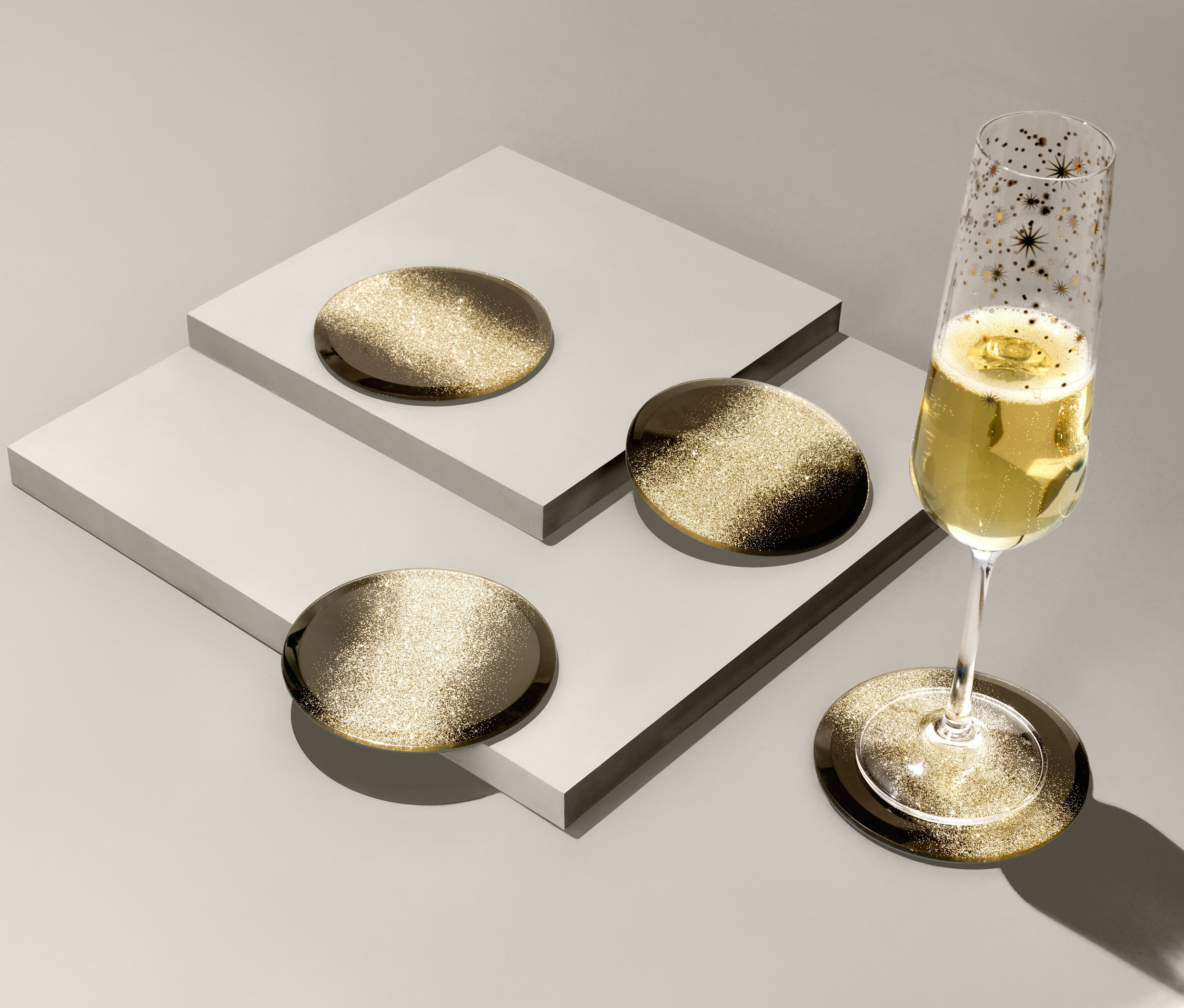 Ein Champagnerglas steht auf einem von 4 Glasuntersetzern.