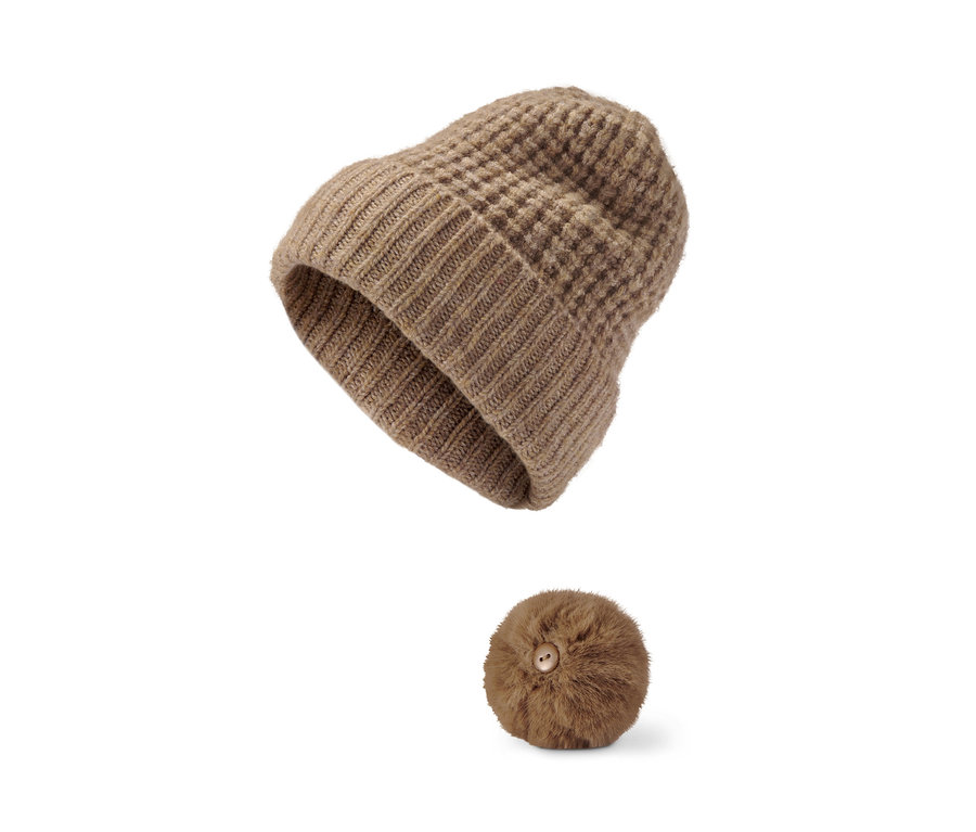 Eine braune Strickmütze mit Bommel und ein separater Bommel mit Knopf.