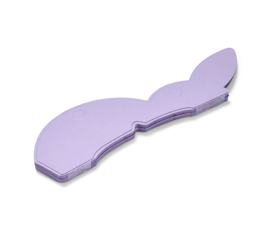 Ein lila Papier-Osterhase liegt auf einem weißen Hintergrund.