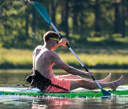 Mann paddelt mit SUP-Sitz »Spinera« auf einem See.