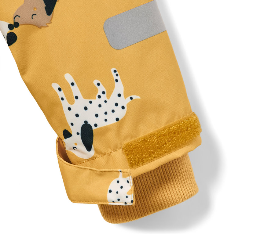 Detailansicht eines gelben Regen-Einteilers mit Hundeprint und Reflexstreifen.