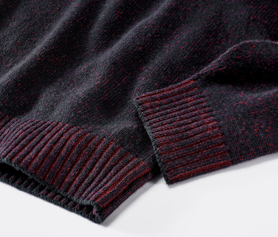 Detailaufnahme eines dunkelblau-roten Pullovers mit Wolle.