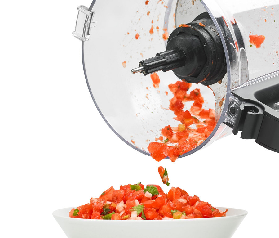 Gehackte Tomaten fallen aus einem KitchenAid Zerkleinerer »5KFP0719« in eine weiße Schüssel.