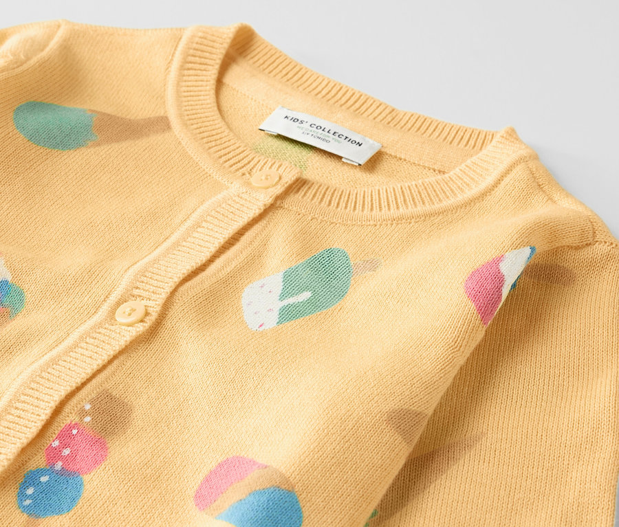 Detailansicht einer Kinder-Strickjacke mit Eiscreme-Motiv.