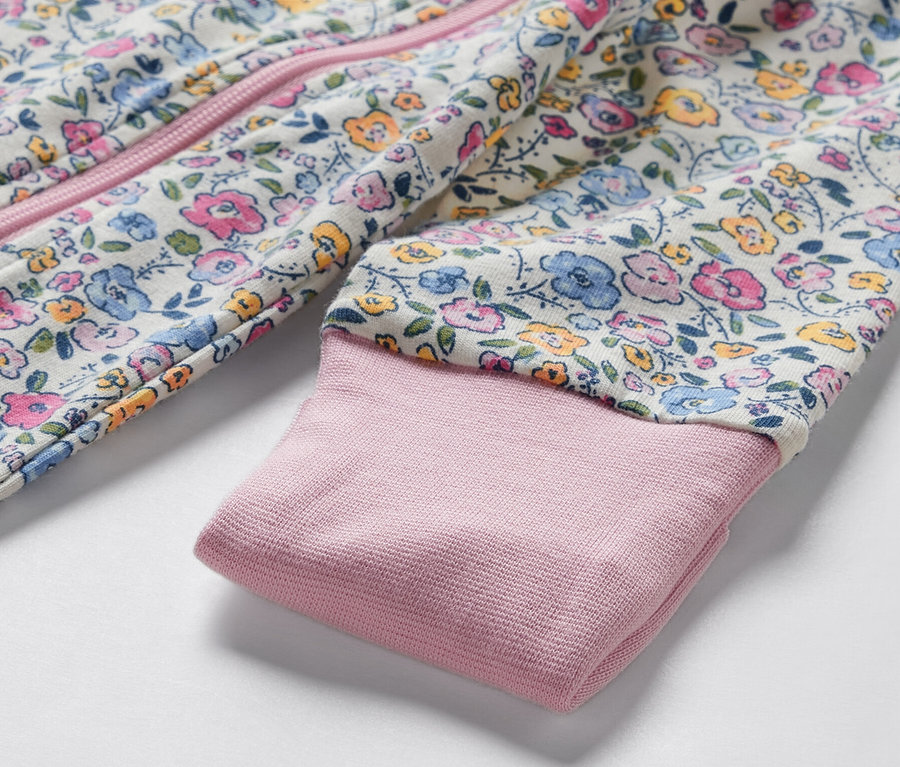 Detailansicht eines Baby-Pyjamas mit Blumenmuster.