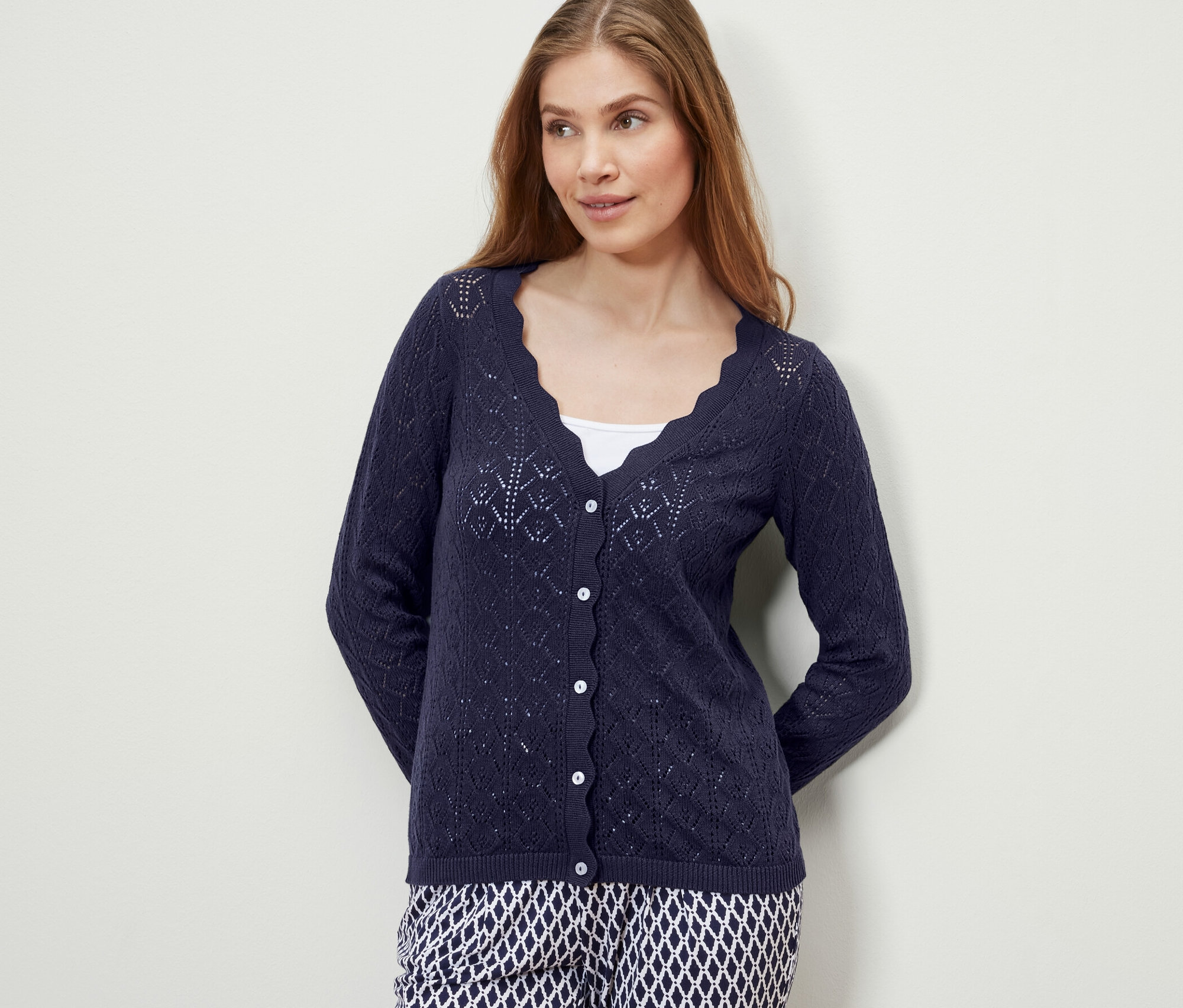 Frau trägt eine dunkelblaue Strickjacke mit Ajour-Muster.