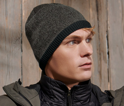 Mann trägt eine Strickmütze und eine Jacke.