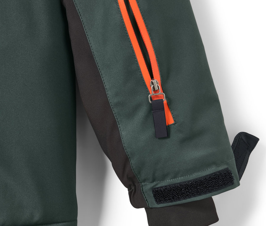 Detail einer Kinder-Skijacke mit orangefarbenem Reißverschluss am Ärmel.