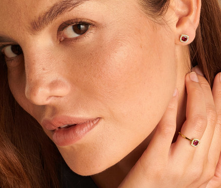 Frau mit 585 Gold Ring Rhodolith und Zirkonia und 585 Gold Ohrstecker Rhodolith und Zirkonia.