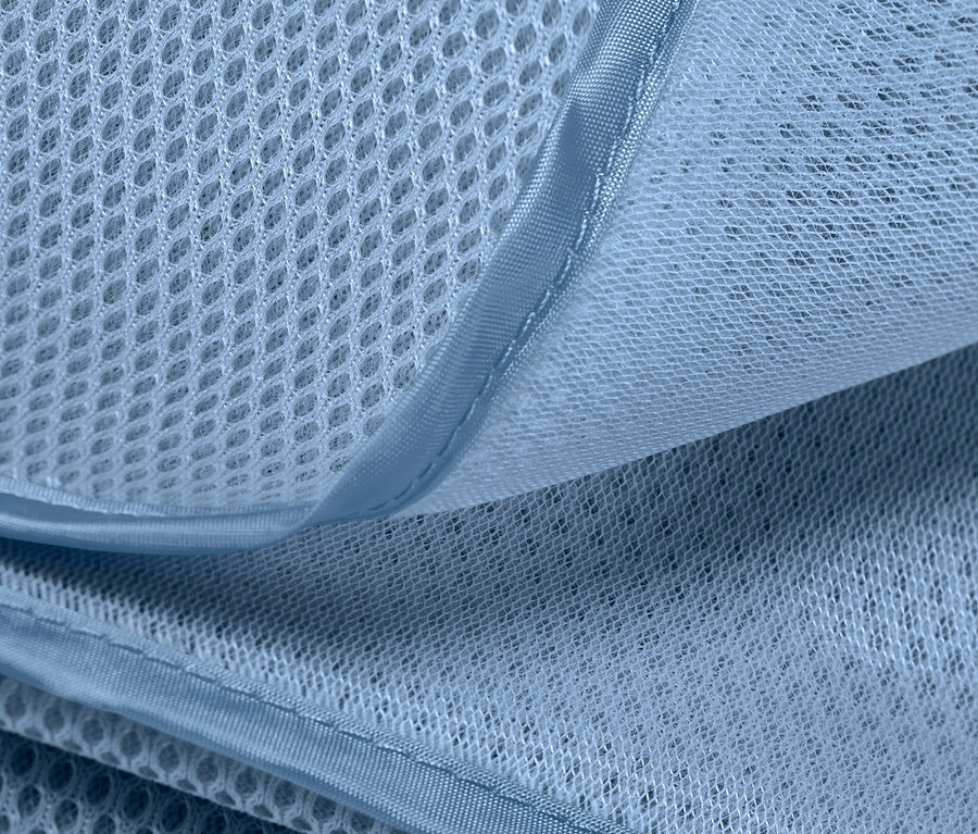 Detailaufnahme einer sandfreien Stranddecke, die die Textur und Atmungsaktivität des Materials zeigt.